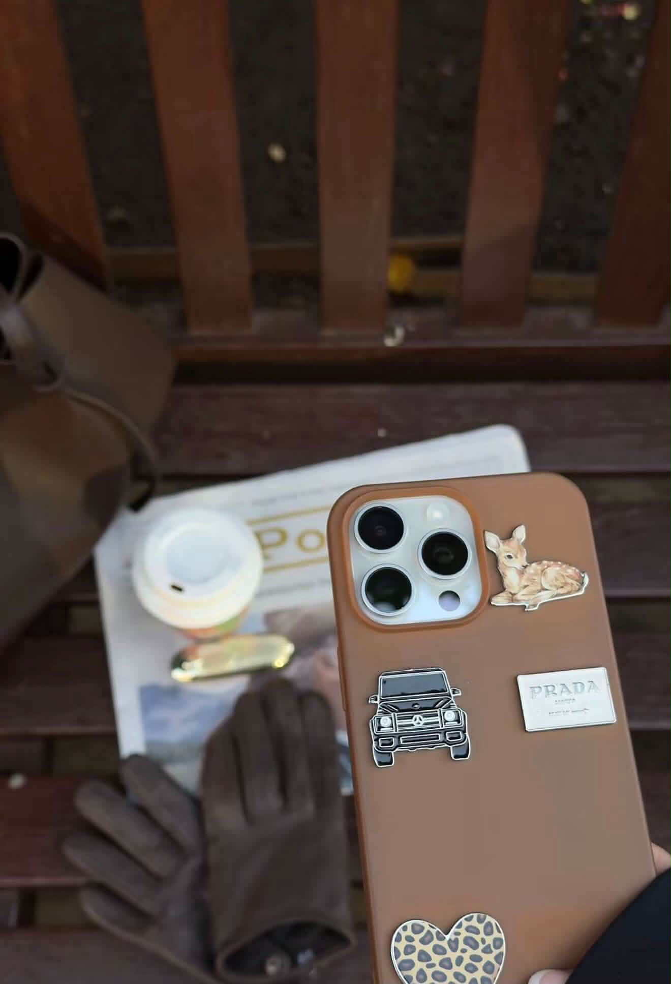 A tan phone case layered with a fawn, a black car, a small label and a leopard print heart sticker